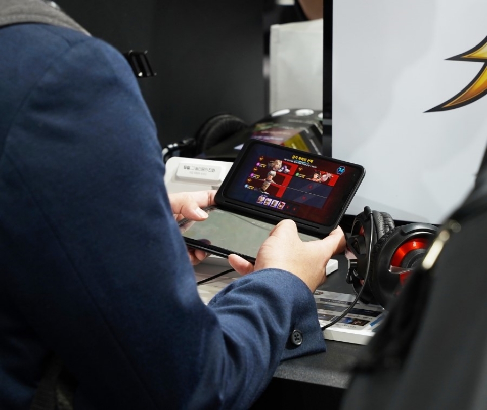 LG V50S ThinQ와 LG 듀얼 스크린으로 게임 패드를 설정하는 관람객