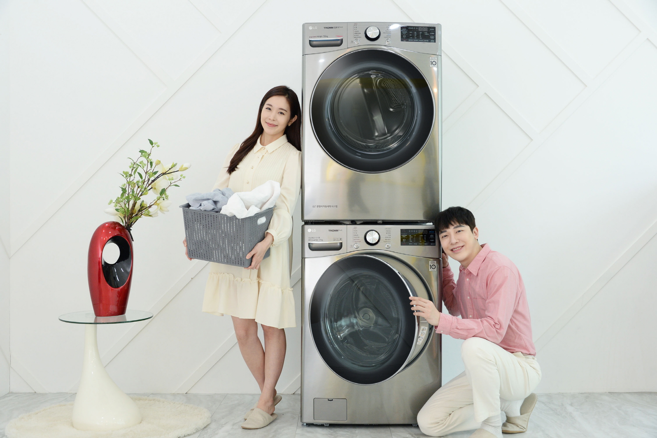 모델들이 'LG 트롬 건조기 스팀 씽큐(상)'와 인공지능 DD세탁기 'LG 트롬 세탁기 씽큐(하)'를 소개하고 있다.