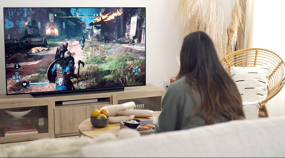 LG 올레드 TV로 거실에서 게임을 즐기고 있는 소비자의 모습