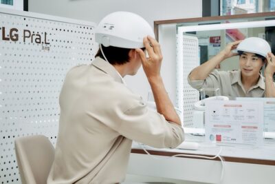 LG전자 모델이 서울 관악구 LG베스트샵 봉천점에서 LG 프라엘 메디헤어를 착용해보고 있다.