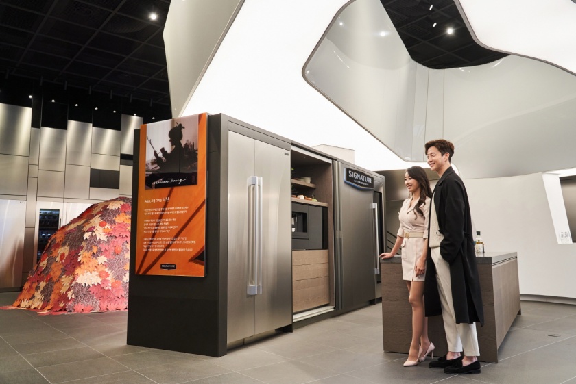 모델들이 시그니처 키친 스위트 제품들과 나난의 작품이 전시된 논현 쇼룸 1층 다다 키친 공간을 관람하고 있다.