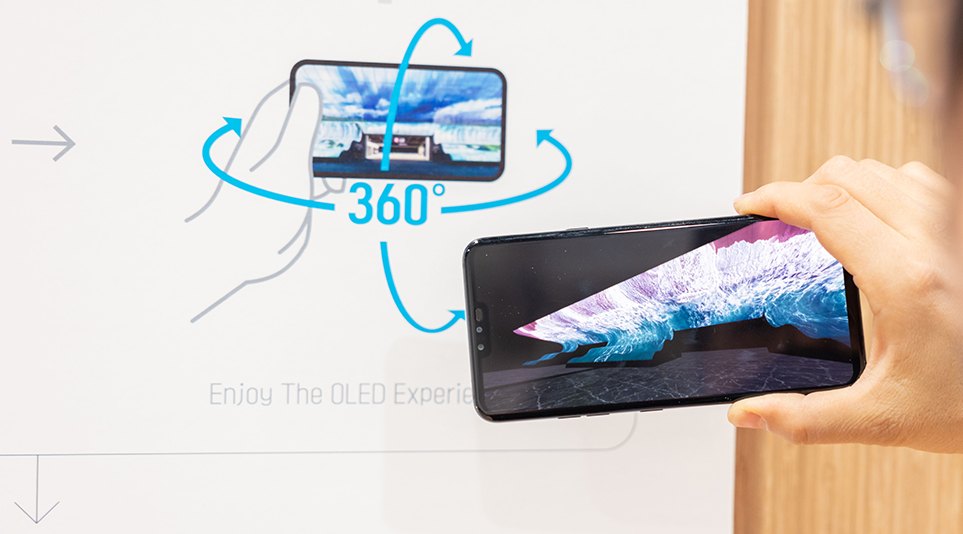 History of OLED Experience Zone에서 스마트폰을 통해 AR 올레드 조형물을 체험하고 있는 모습