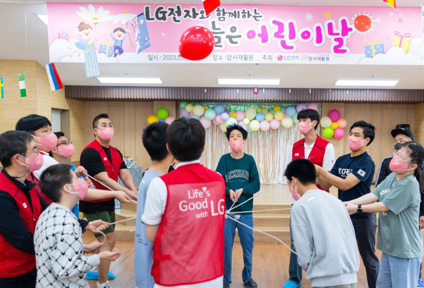 LG전자는 어린이날을 맞아 4일 서울 암사재활원에 거주하는 장애 아동·청소년들을 위해 행사를 가졌다. 사진은 암사재활원 강당에서 LG전자 직원들과 장애아동들이 협동 공던지기를 하는 모습.