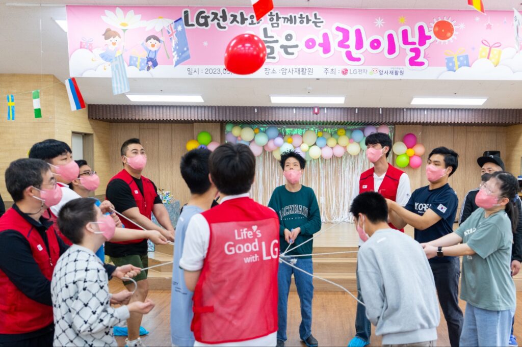 LG전자는 어린이날을 맞아 4일 서울 암사재활원에 거주하는 장애 아동·청소년들을 위해 <오늘은 어린이날> 행사를 가졌다. 사진은 암사재활원 강당에서 LG전자 직원들과 장애아동들이 협동 공던지기를 하는 모습.