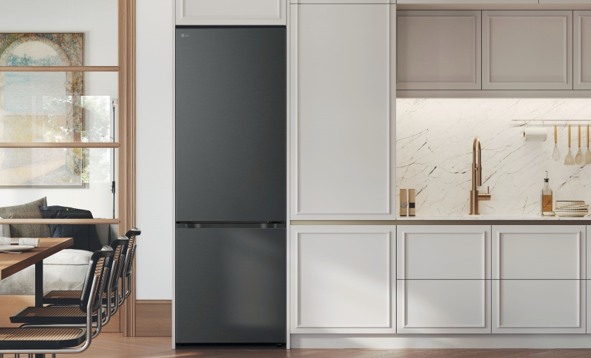 주방 공간. 왼쪽에는 식탁과 의자가 보이고, 오른쪽에는 대리석 무늬의 벽면과 싱크대, 수전이 있음. 왼쪽 벽면에 검은색 양문형 냉장고가 붙박이 형태로 설치되어 있음. 전체적으로 흰색과 베이지 톤의 깔끔한 인테리어.