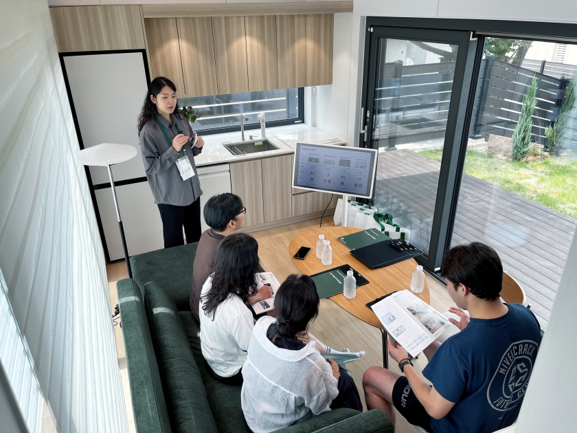 LG 스마트코티지’를 둘러보고 있는 방문객들. 스마트코티지에 대해 설명해 주고 있는 담당자와 이를 경청하는 4명의 뒷모습