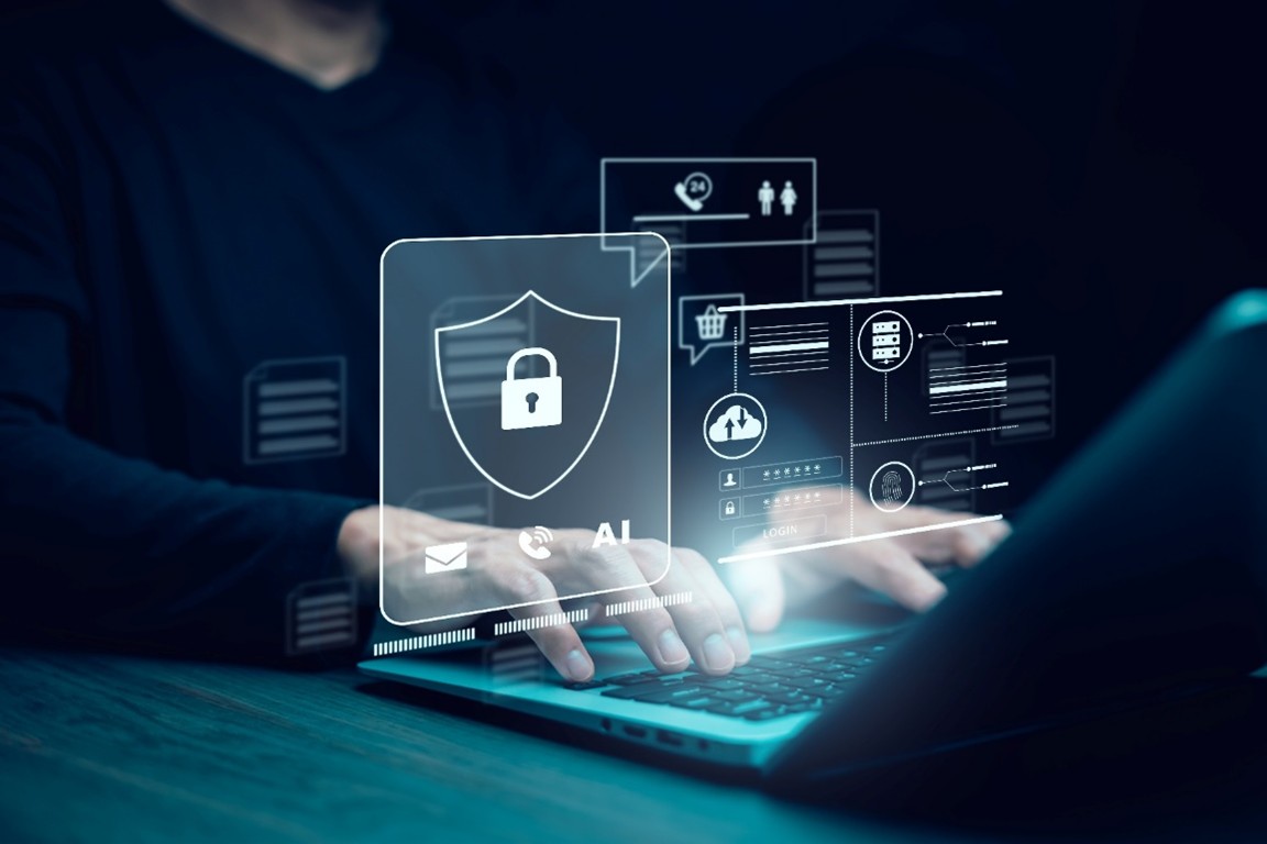 노트북을 사용하는 사람의 손 위로 투명한 보안 아이콘들이 겹쳐진 이미지. 중앙에는 자물쇠가 있는 방패 모양 아이콘이 크게 보이고, 그 주변에는 로그인 창, 서버, 사람, 지문, 메일, 쇼핑 카트 아이콘 등이 떠 있다. 화면에는 ‘AI’, ‘LOGIN’이라는 단어가 표시되어 있다.