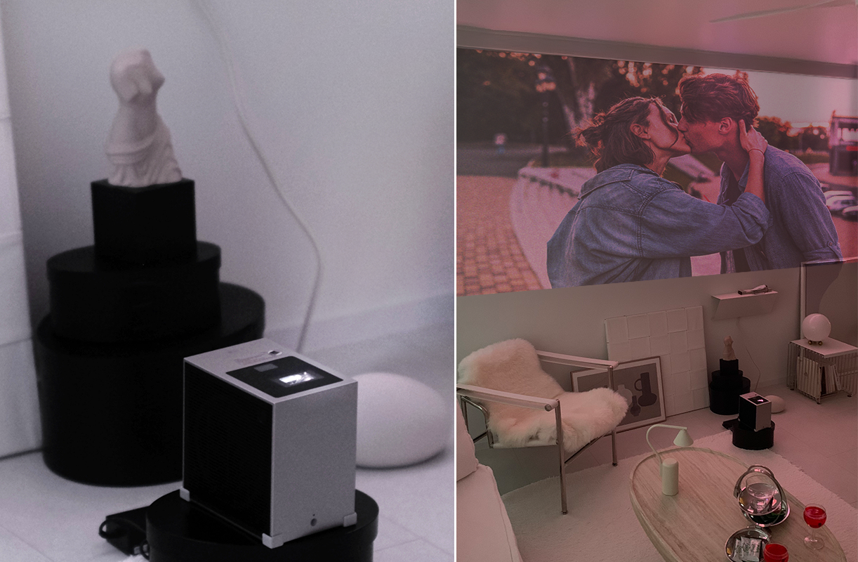 왼쪽 장면에서는 어두운 톤의 받침 위에 시네빔이 놓여 있고, 그 뒤에는 조형물과 둥근 조명이 배치된 미니멀한 공간이 보인다. 오른쪽 장면에서는 시네빔이 벽에 데님 재킷을 입은 두 사람이 키스하는 장면을 크게 투사하고 있다. 주변에는 퍼 소재 의자, 액자, 조명, 테이블 소품 등이 놓여 있어 은은한 핑크빛 조명이 번지는 감각적인 실내 분위기가 연출된다.