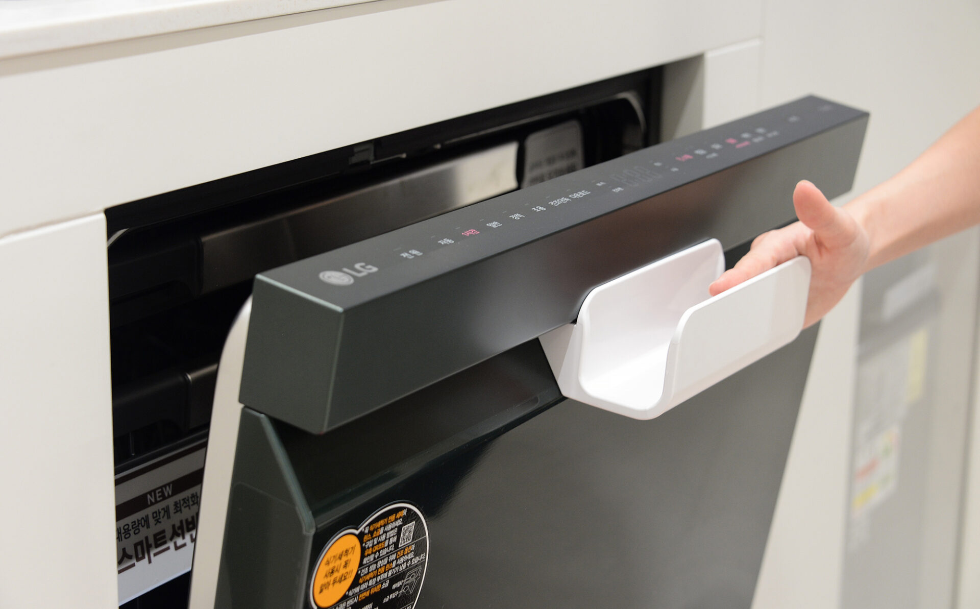 고객이 '식기세척기 이지핸들(도어)'를 이용해 식기세척기 문을 열고 있는 모습.