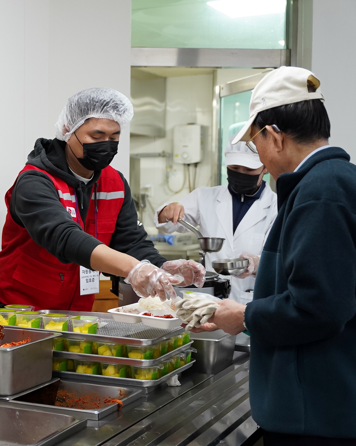 LG전자 임직원들로 구성된 ‘라이프스굿 봉사단’이 구립용산장애인복지관 이용자들에게 김장 김치와 수육 등으로 구성된 나눔 밥상을 전달하는 모습.  